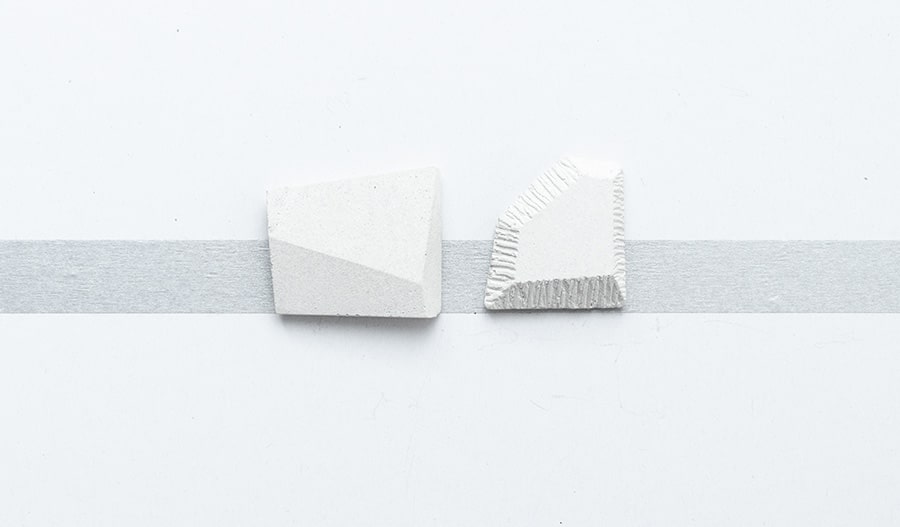 Apró fehér beton bross, geometrikus formavilággal.