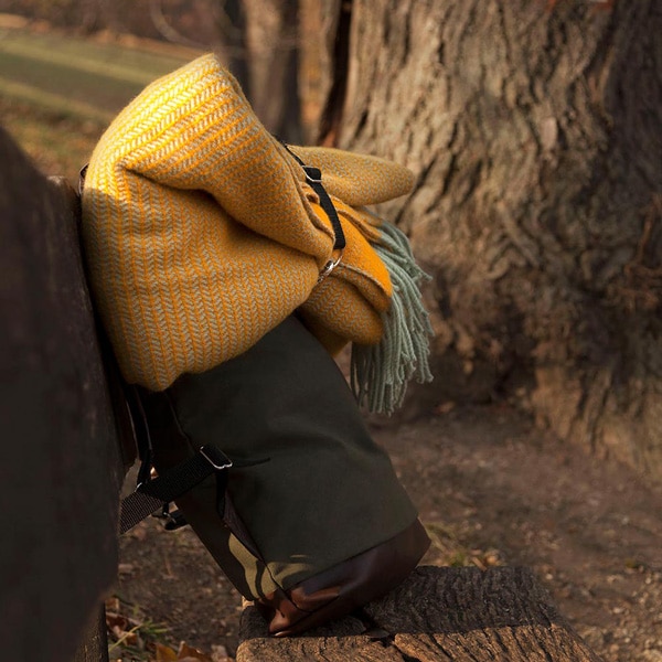 napsárga gyapjú takaró őszi kiránduláson hátizsákra rögzítve